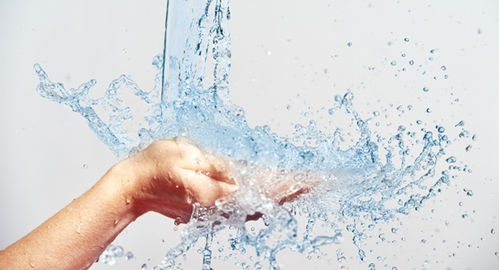 woman hand with water splashes and drops